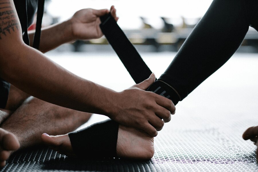 Bandážovanie členka pri stabilnom poranení – aplikácia kompresie pomocou elastickej bandáže. Foto: https://www.pexels.com/cs-cz/foto/osoba-sport-sportovci-noha-7991959/