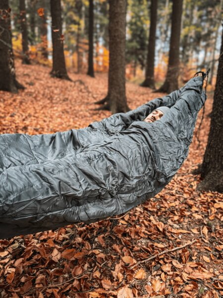 Hamaka s kokonovým spacákom Cocoon zavesená medzi stromami, izolácia na spanie v chladných podmienkach v prírode. Foto: Rigad