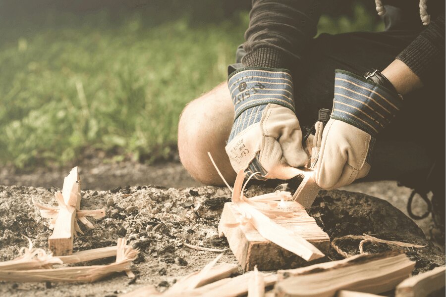 Zakladanie ohňa v rukaviciach pomocou kresadla. Zdroj: https://www.pexels.com/cs-cz/foto/167708/