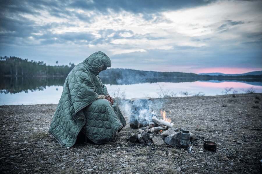 Núdzové zateplenie v zime – použitie zatepleného ponča pri nocovaní vonku v chladných podmienkach. Foto: Helikon-Tex, Rigad