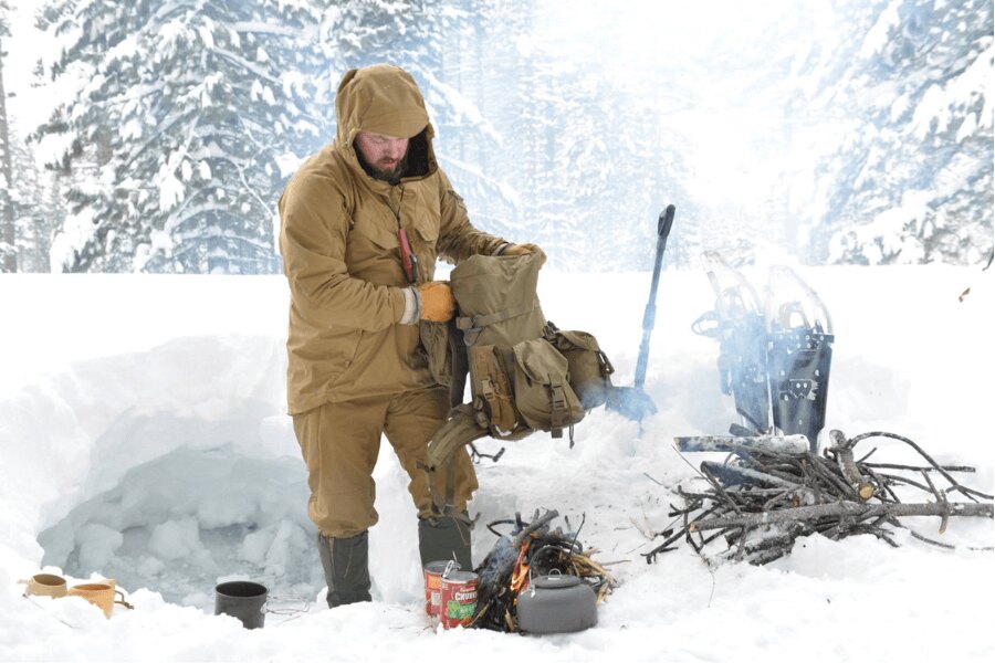 Príprava výbavy a teplého zázemia pri zimnom nocovaní na snehu pred zotmením. Foto: Helikon-Tex, Rigad