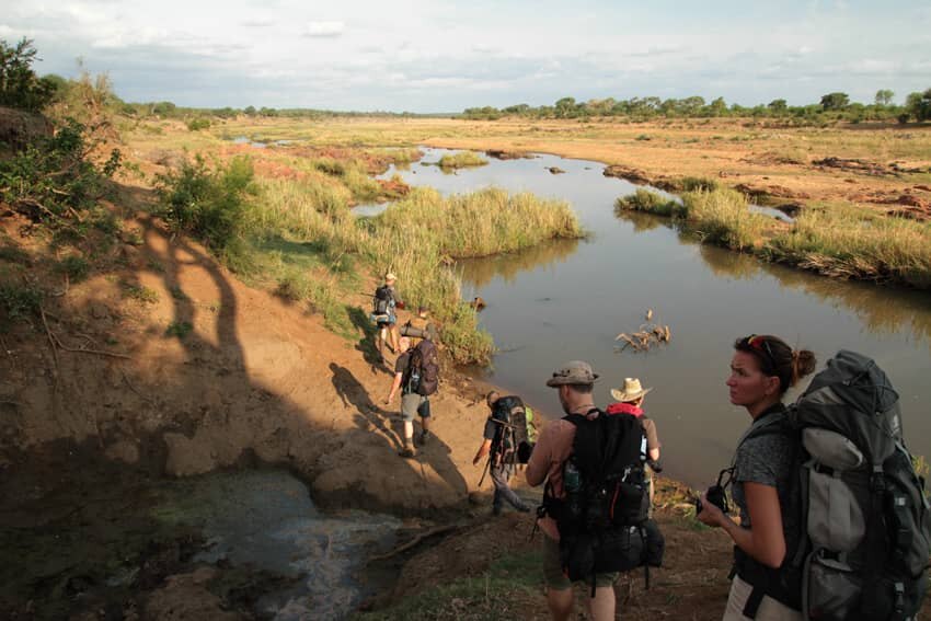 Ľudia kráčajúci za sebou v africkej prírode
